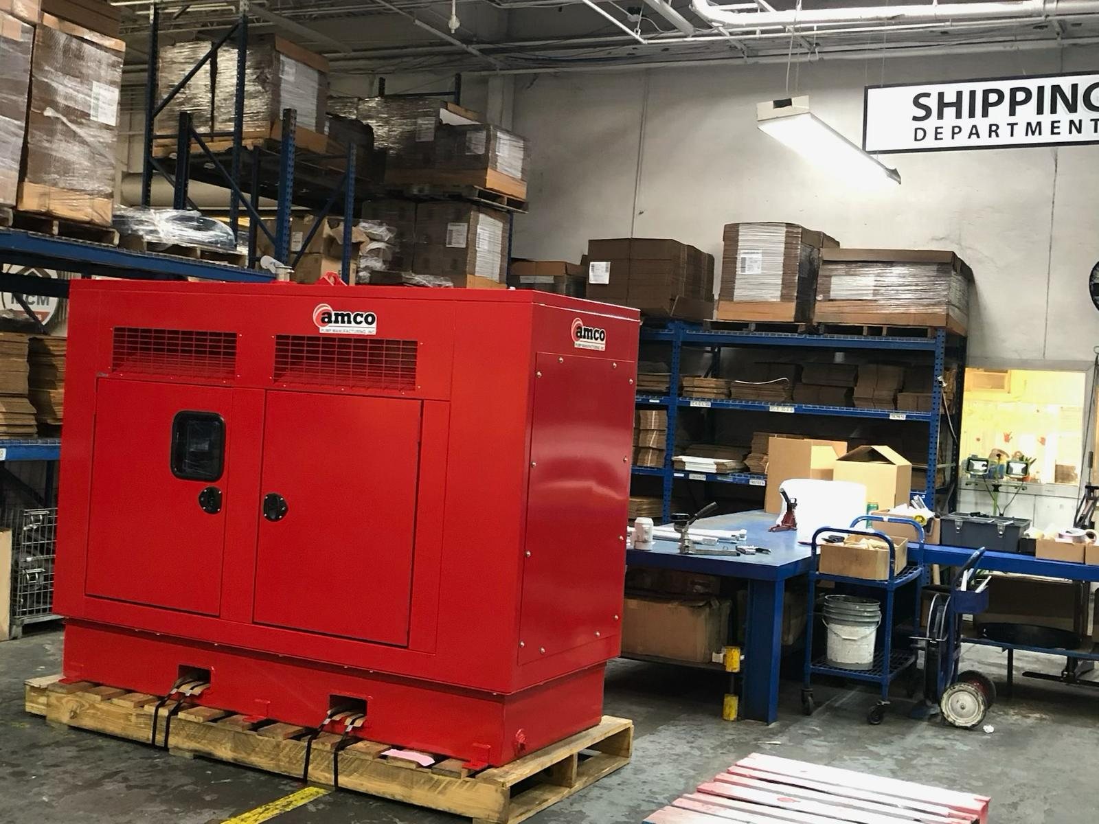 Red AMCO sound-attenuated pump enclosure in the shipping department awaiting crating