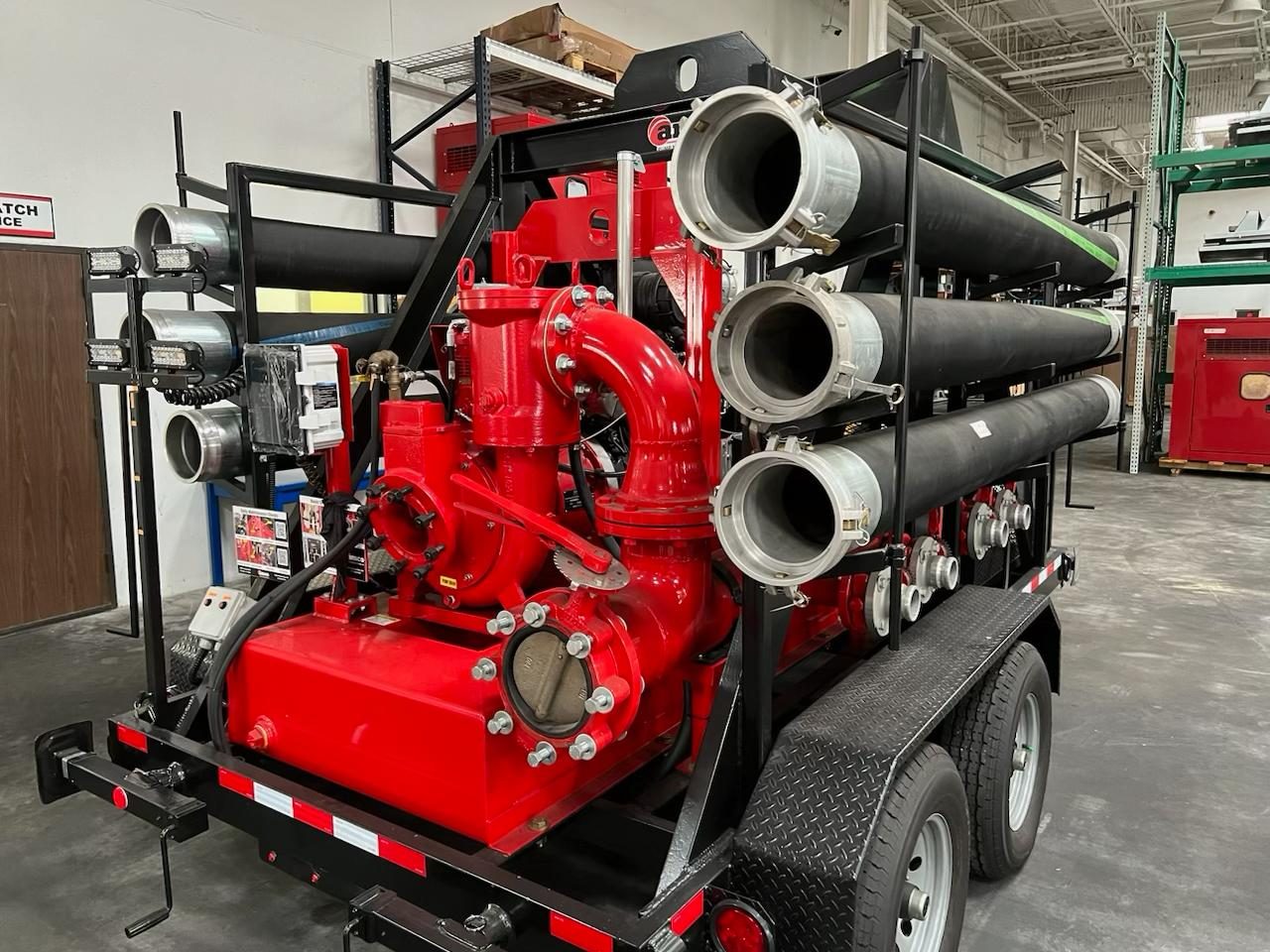 AMCO red trailer-mounted diesel auto-prime dewatering pump with suction hose racks