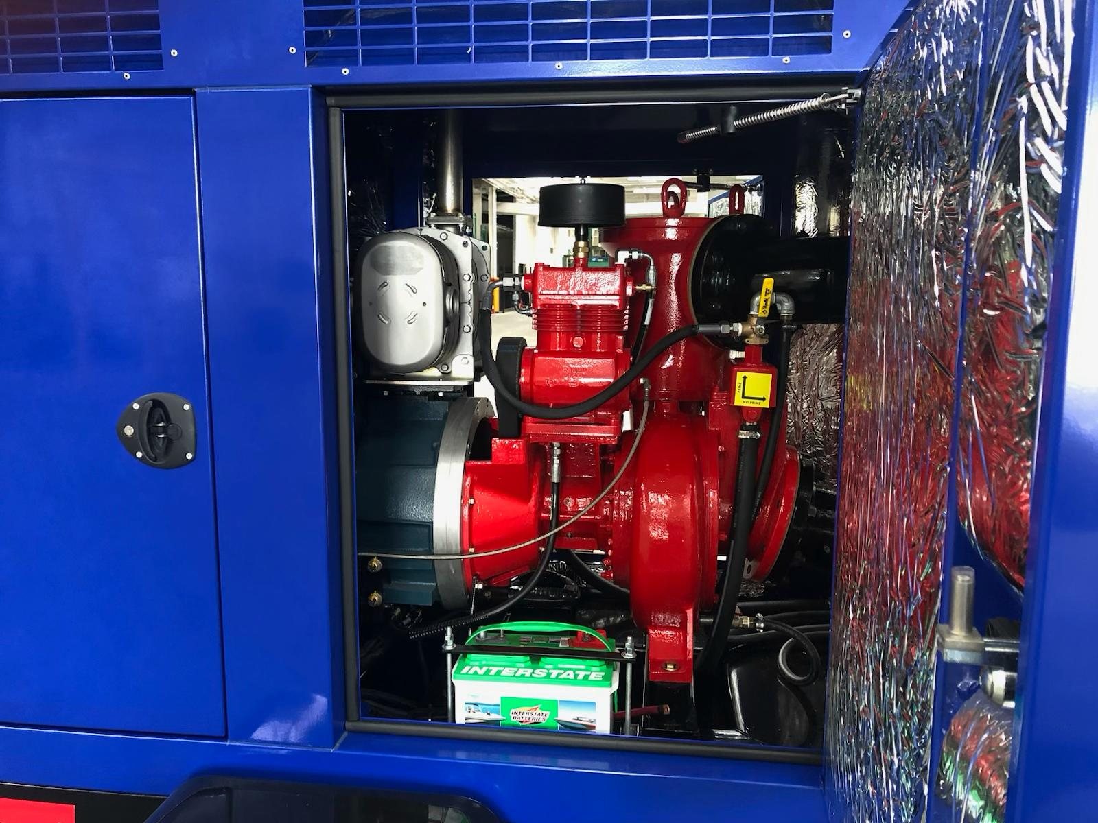 Interior of an AMCO acoustic enclosure showing the red pump end and priming chamber