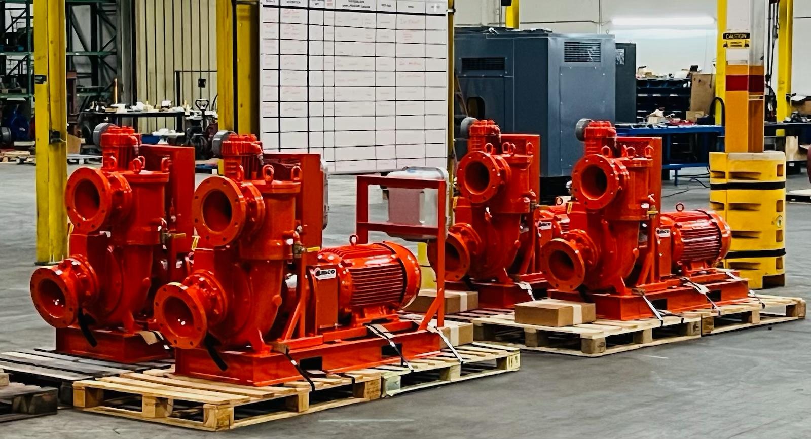 Row of AMCO STP self-priming trash pump ends staged on pallets in the Houston plant